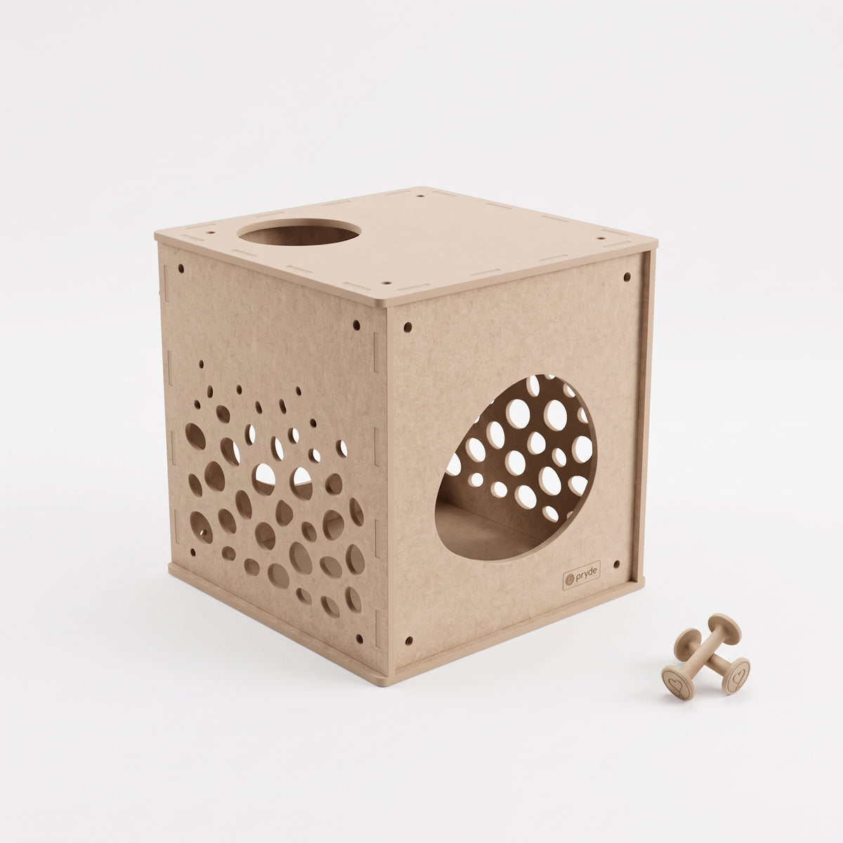 A light natural wood cube-shaped cat playhouse with circular entry and exit holes, shown on a clean white background with two small wooden toy dumbbells nearby.